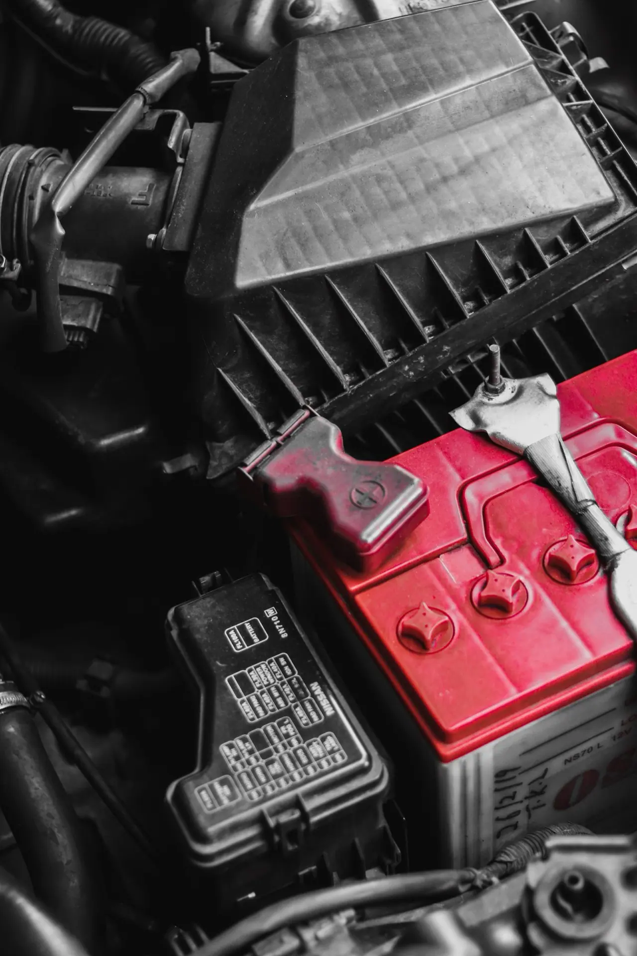 Close-up of a car battery with red terminal covers