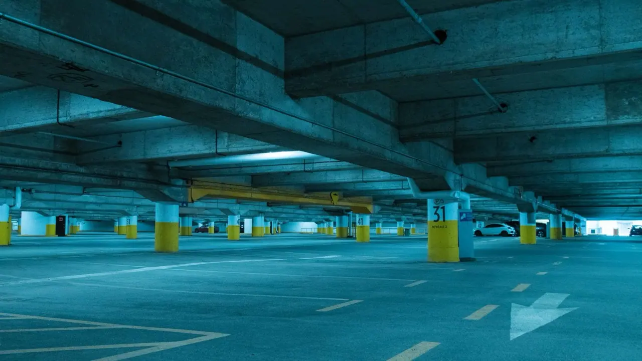 An empty underground parking level under blue light