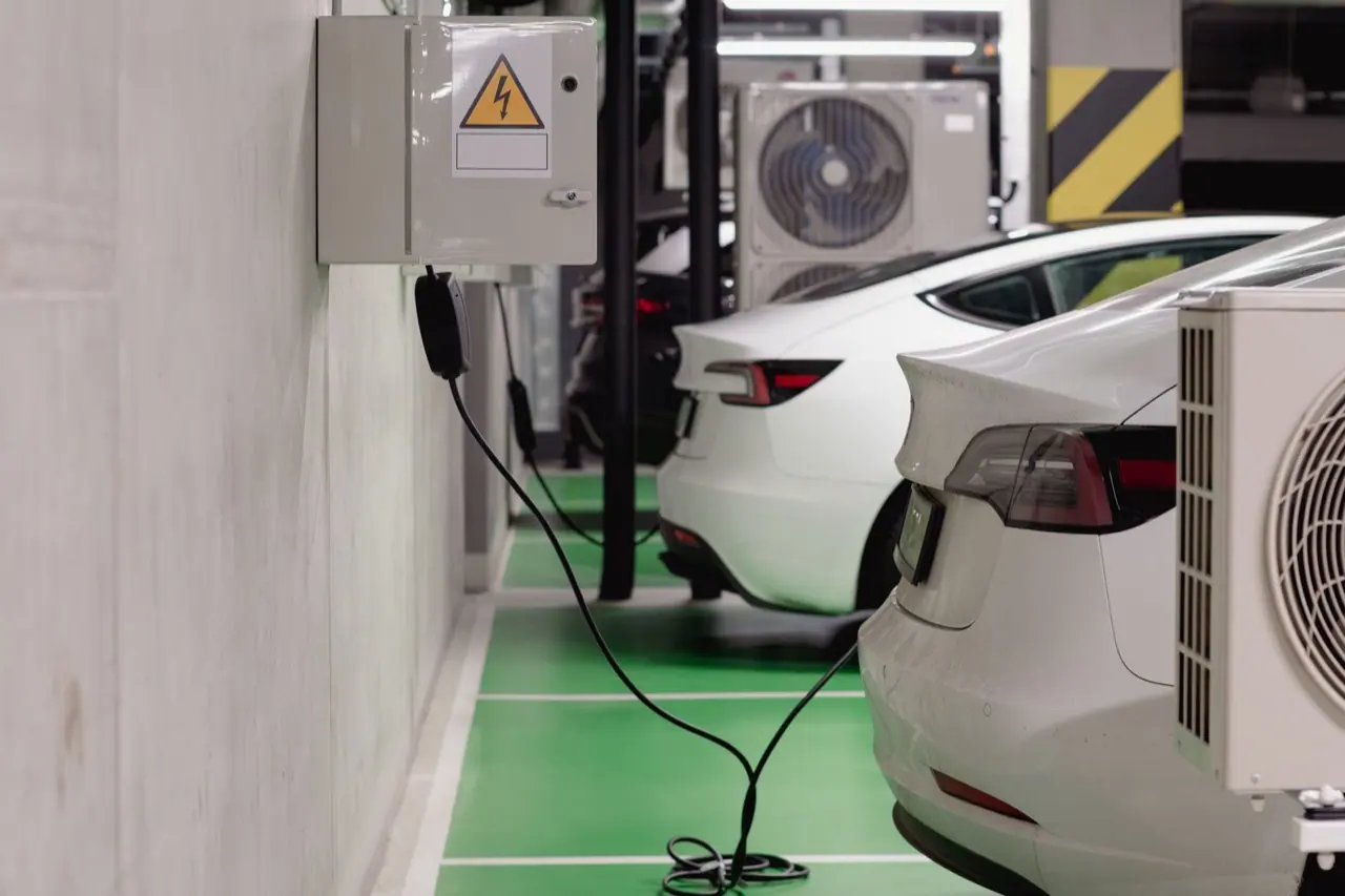 Electric cars plugged into wall chargers in an underground garage