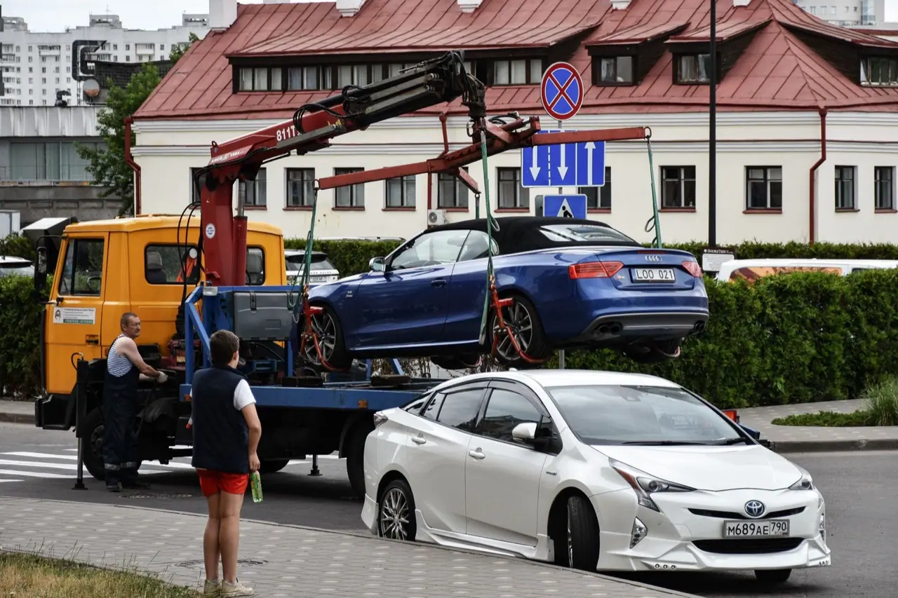 A car being loaded onto a flatbed tow truck on a city street